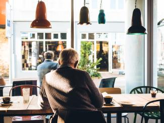 Man in coffee shop reading a newspaper